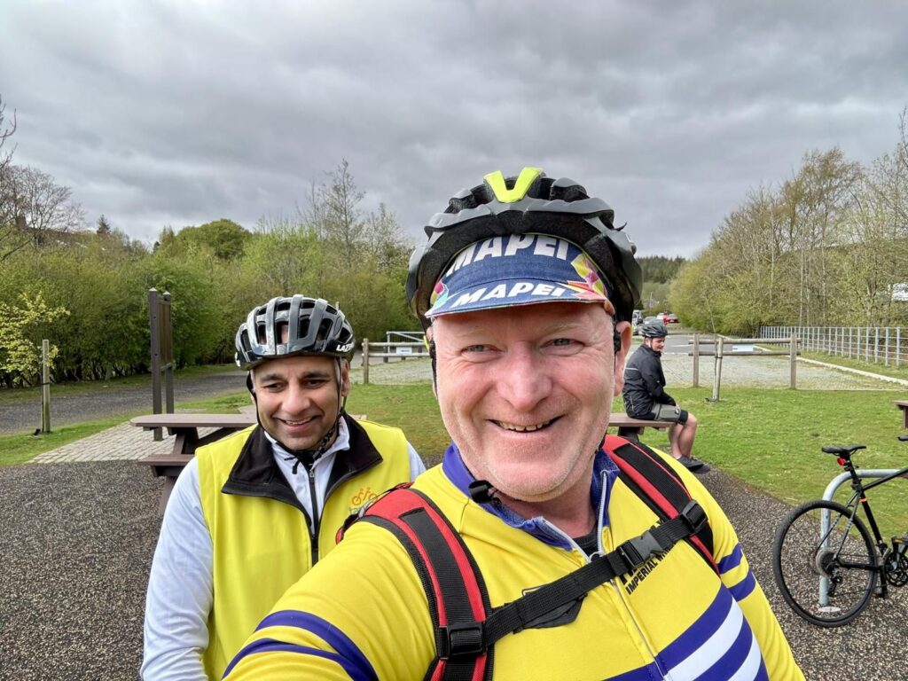 



Muz and Mark stand by their tandem smiling for the camera, a country park like area behind them.