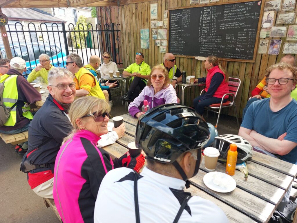A group of trekkers sat around a wooden picnic table
